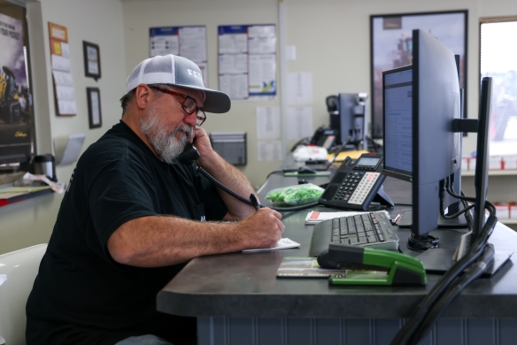 Alliance Ag warranty administrator writing down customer information on a note pad.